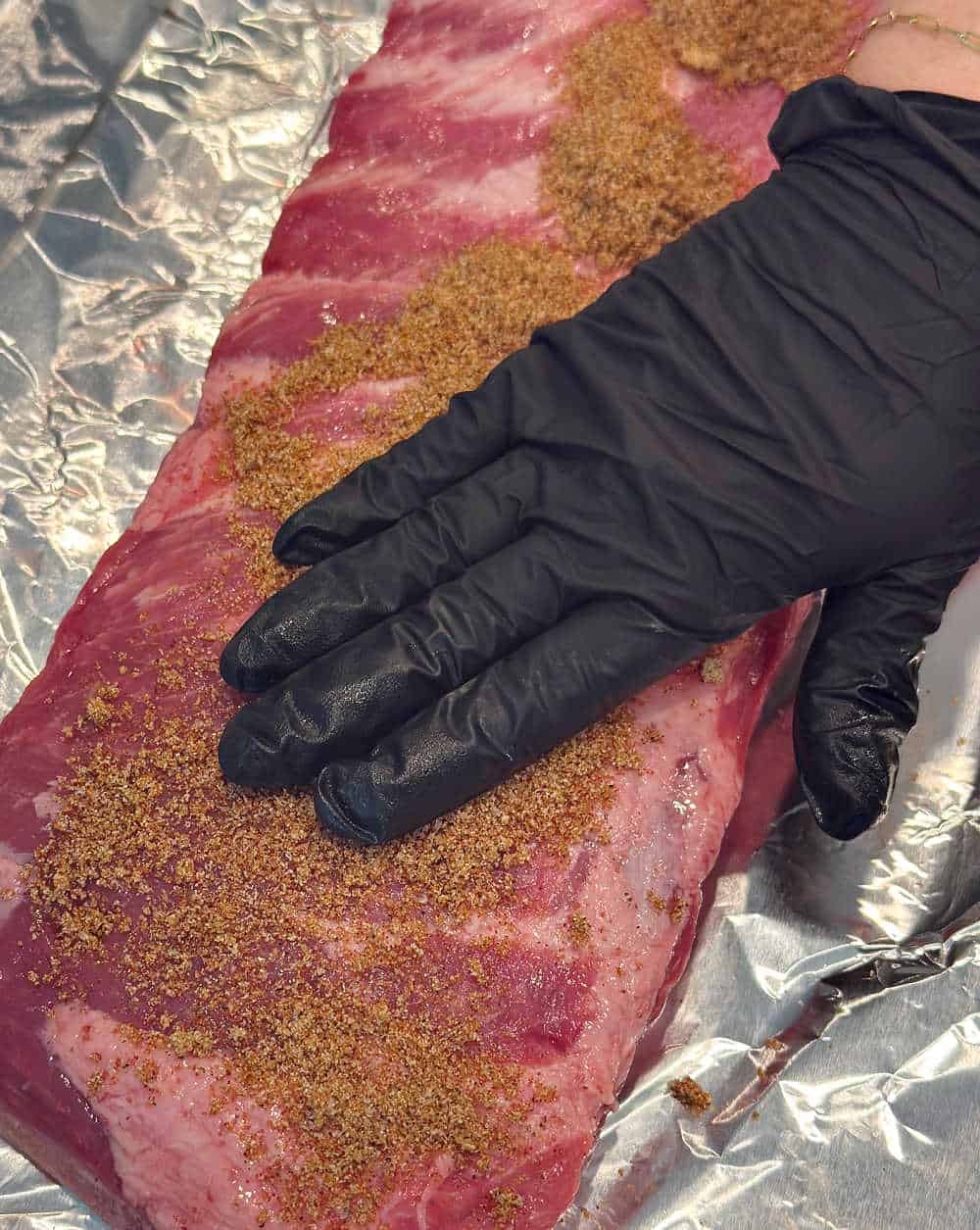 rubbing spice mixture over ribs.
