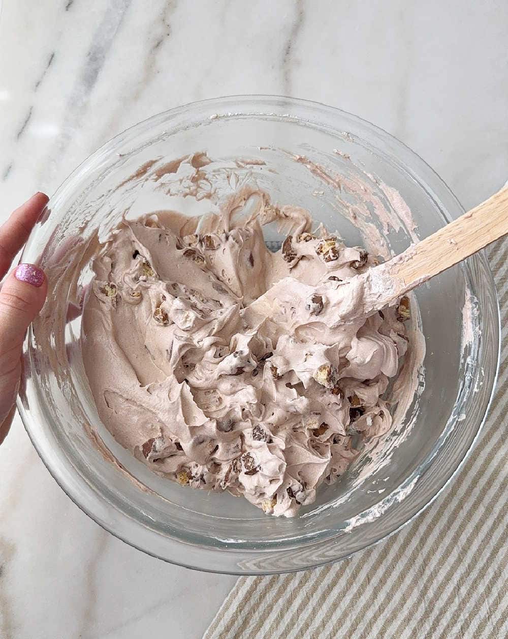 mixing in candy with spatula.