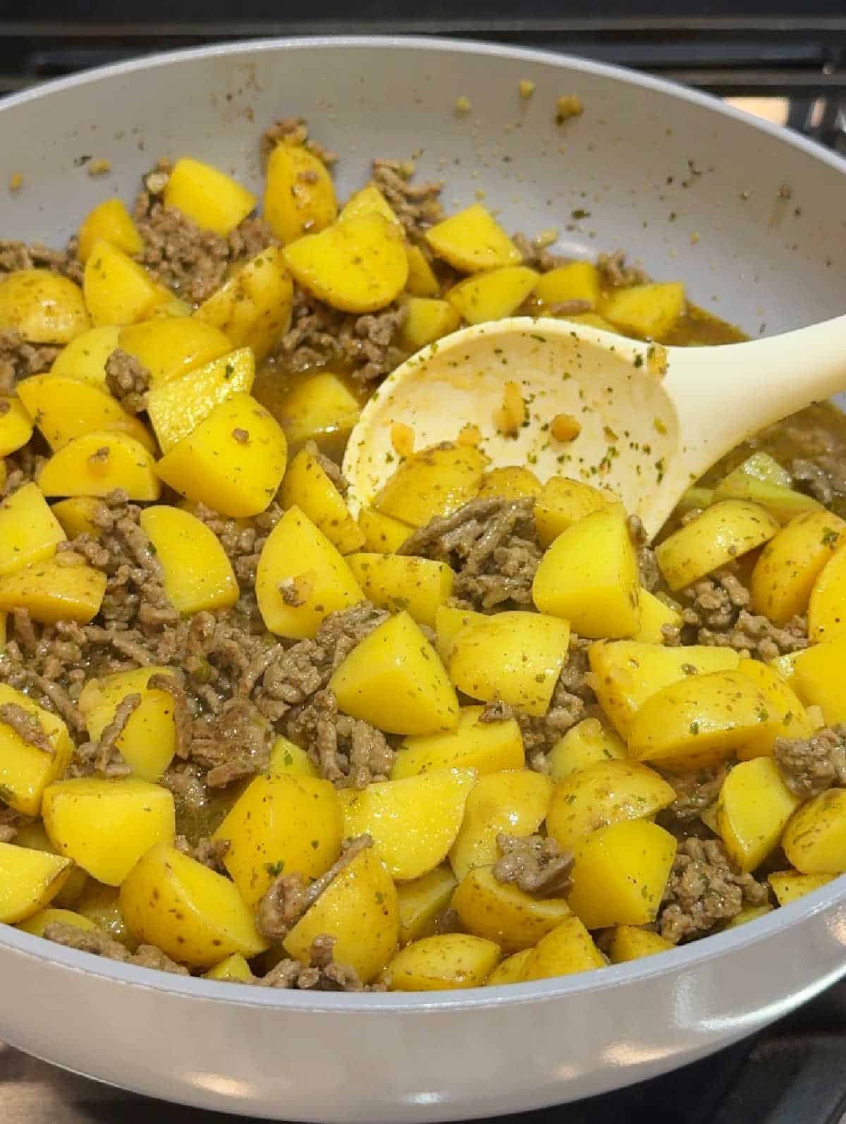 stirring meat and potatoes.