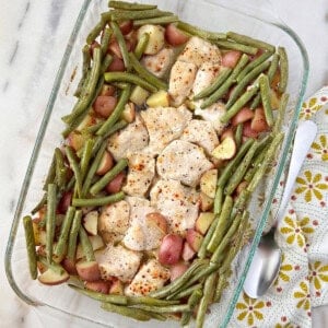Italian chicken with potatoes and green beans in pan.