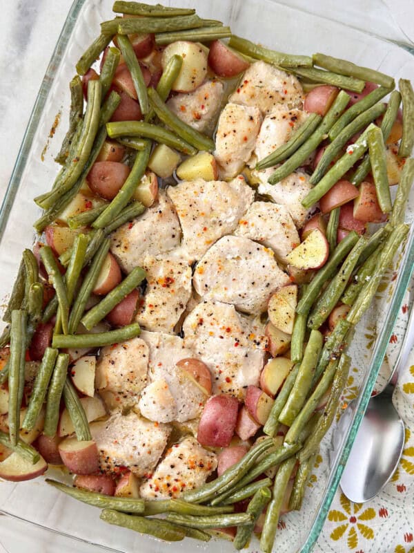 Italian chicken with potatoes and green beans in pan.