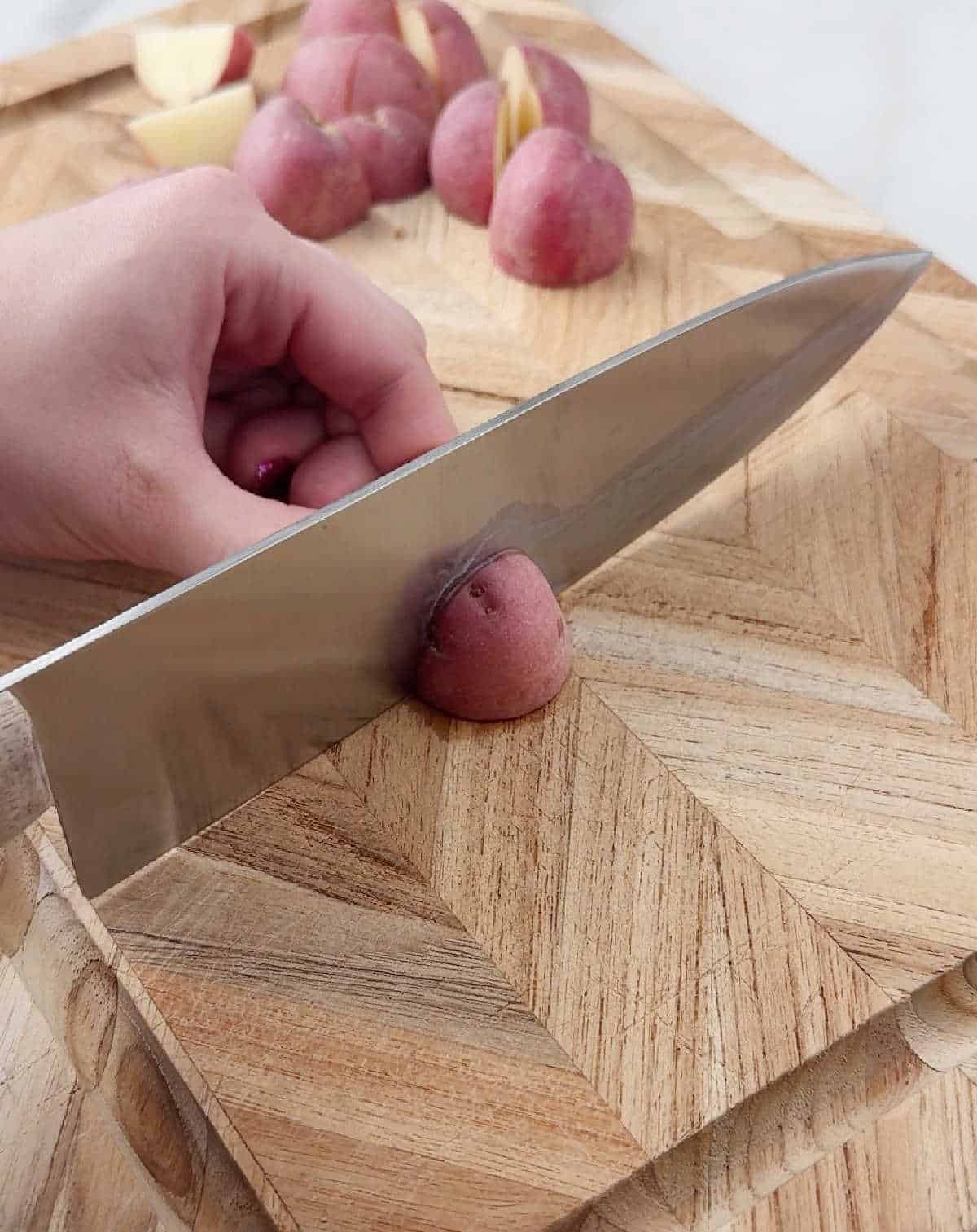 slicing red potatoes on cutting board.