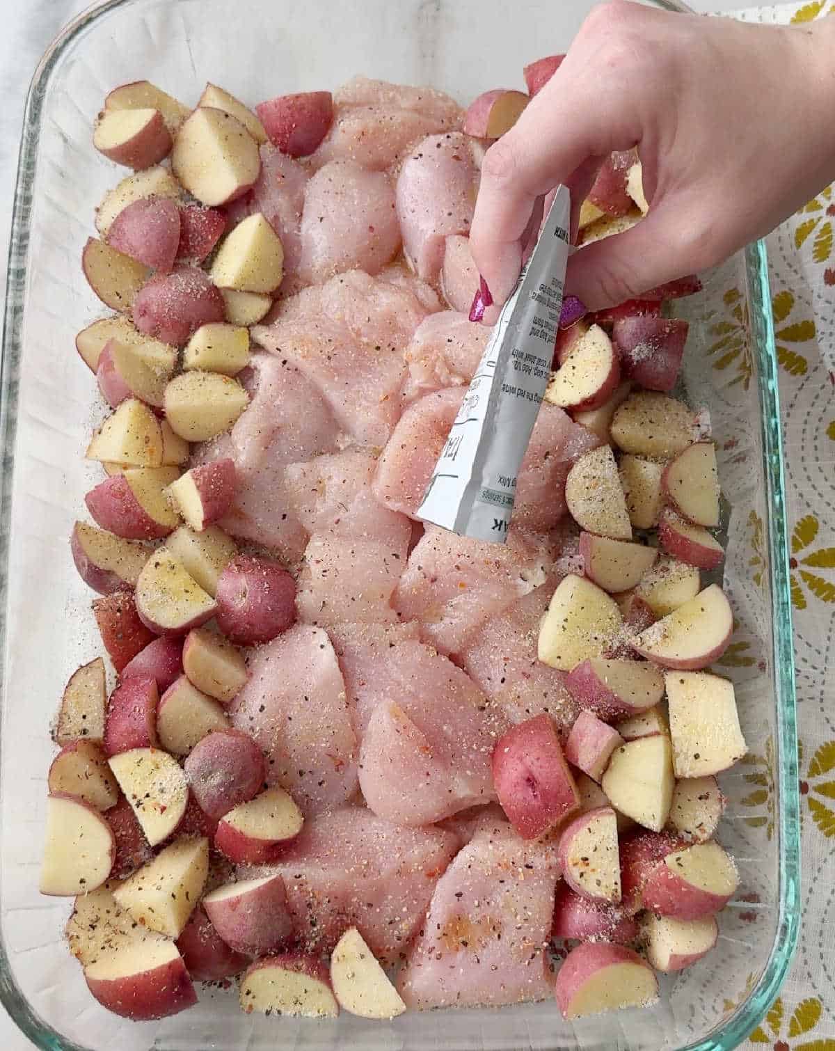 sprinkling seasoning packet over food.