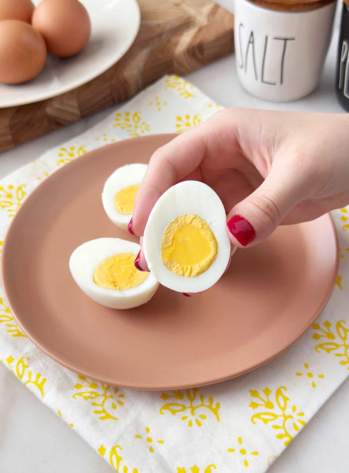 holding sliced hard boiled egg in hand.