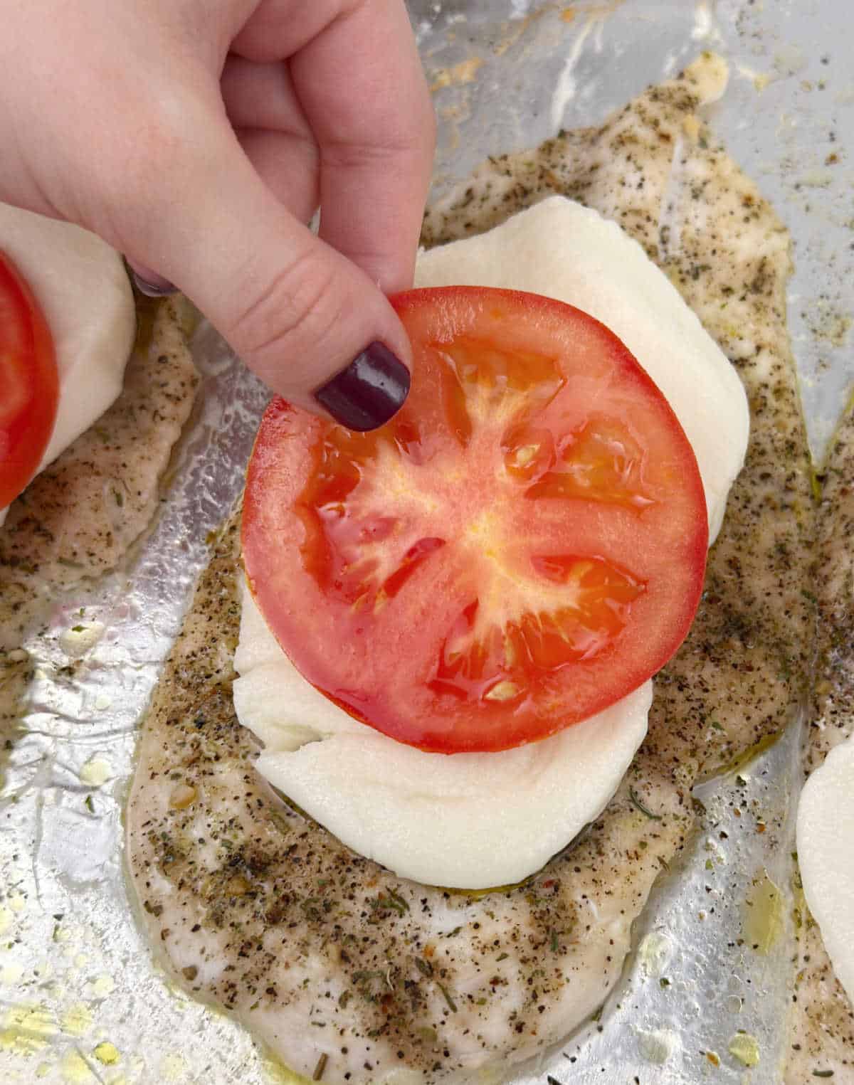 adding tomato slice over cheese.