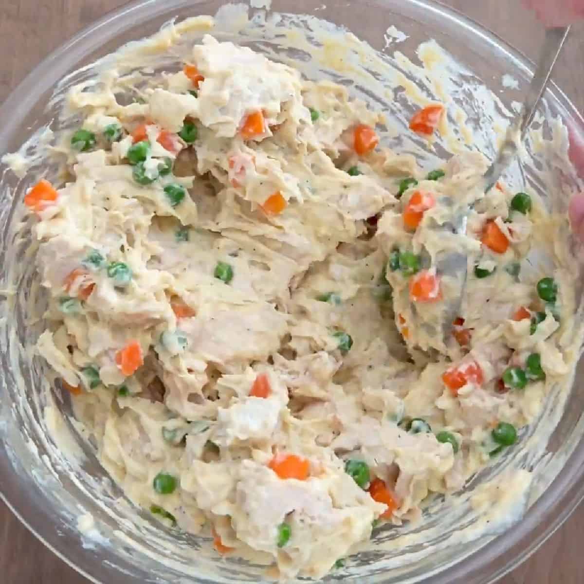 mixing casserole ingredients in glass bowl.