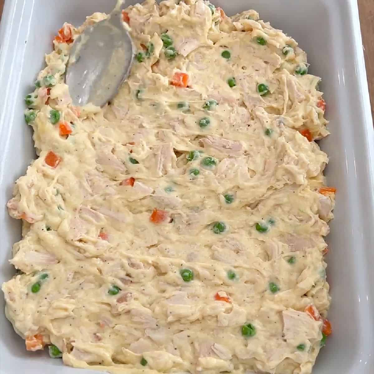 spreading pot pie filling in baking dish.