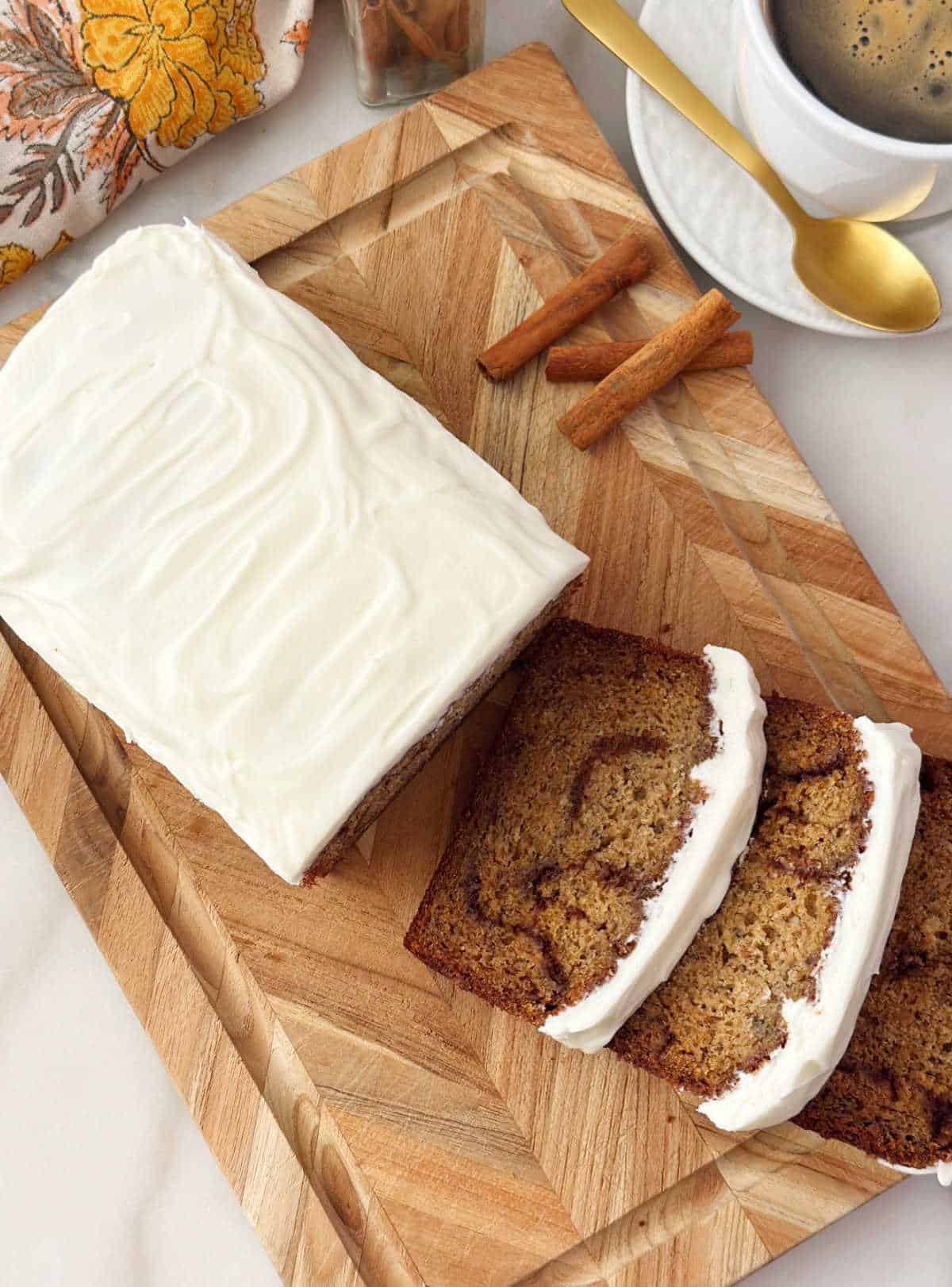 cinnamon roll banana bread sliced on cutting board.