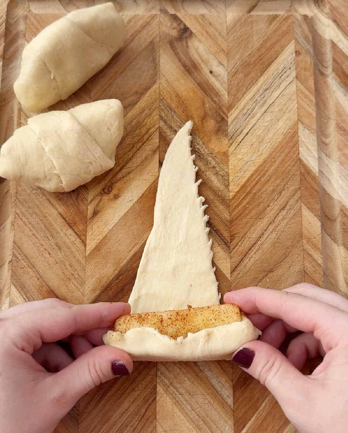 rolling apple slices in dough.