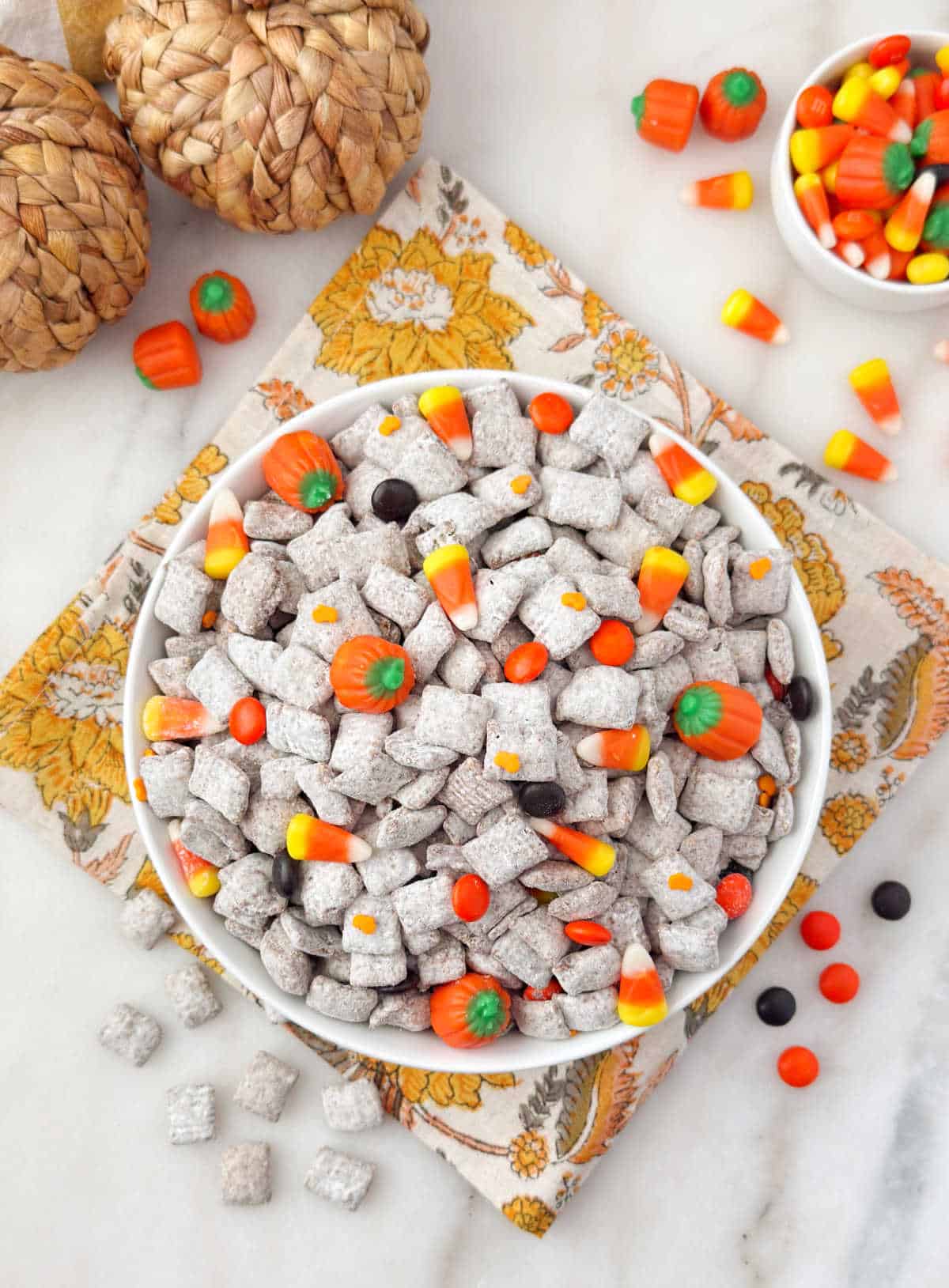 Bowl of fall puppy chow with harvest candy and chex mix.