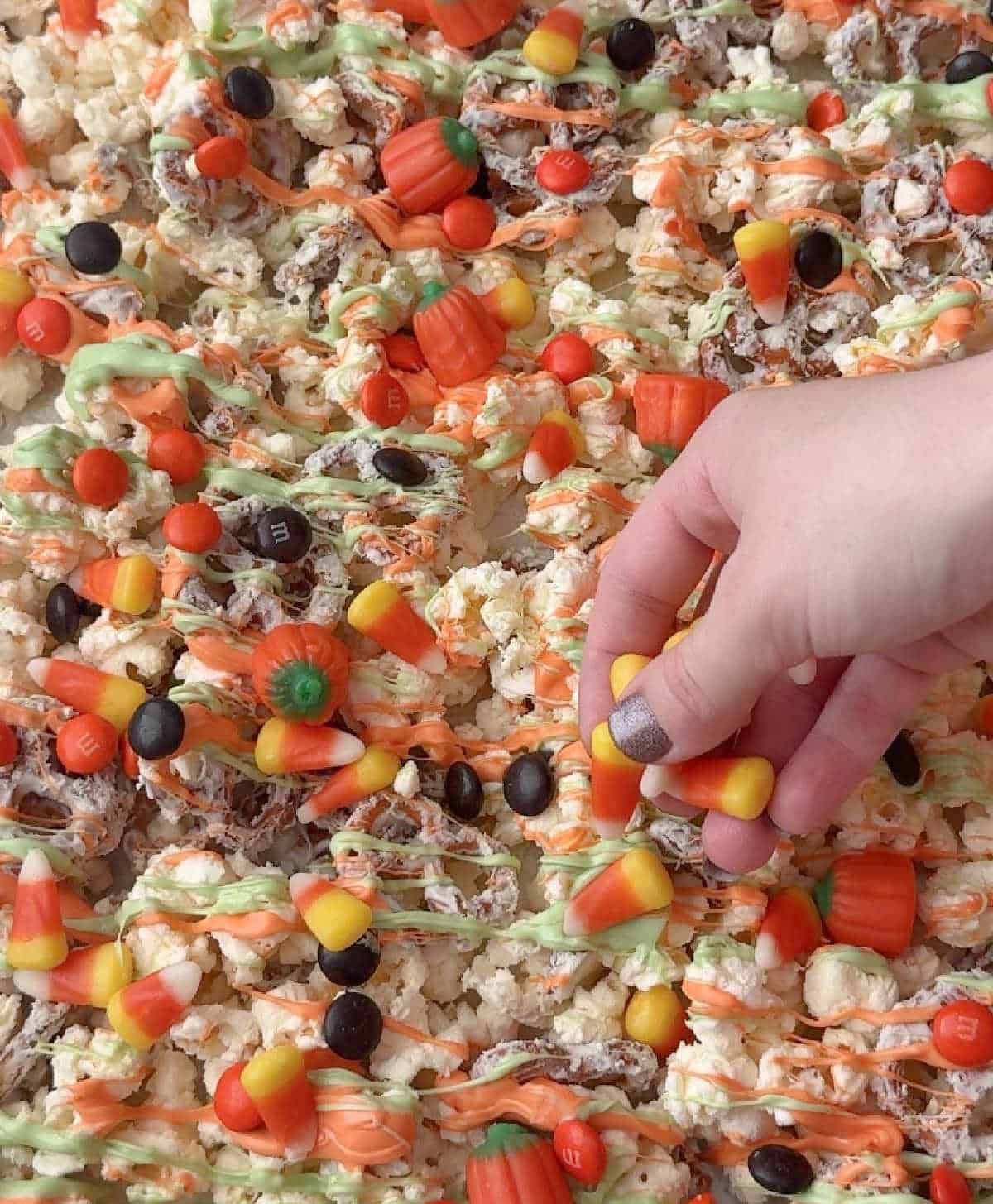 adding candy to snack mix.