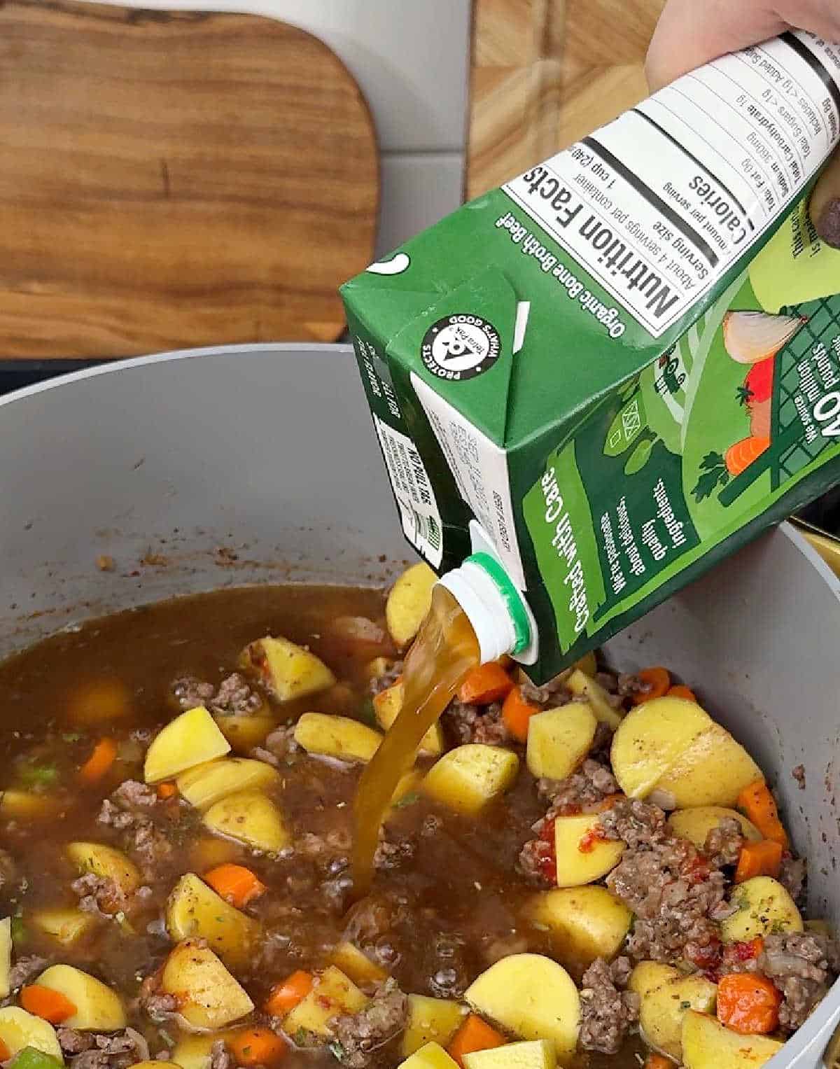 pouring broth into stew.