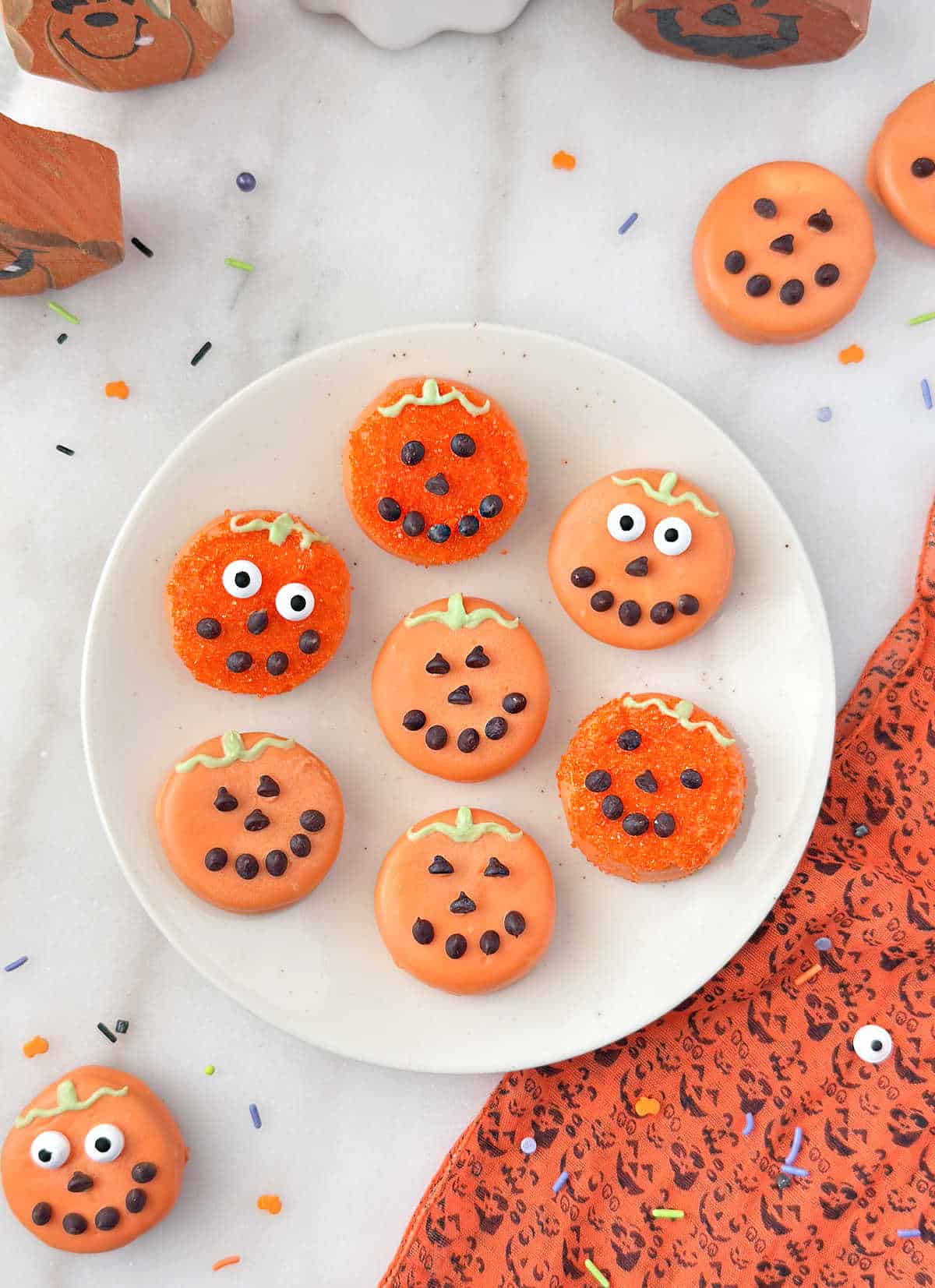 plate of Oreo pumpkin cookies dipped in orange candy melts for Halloween.