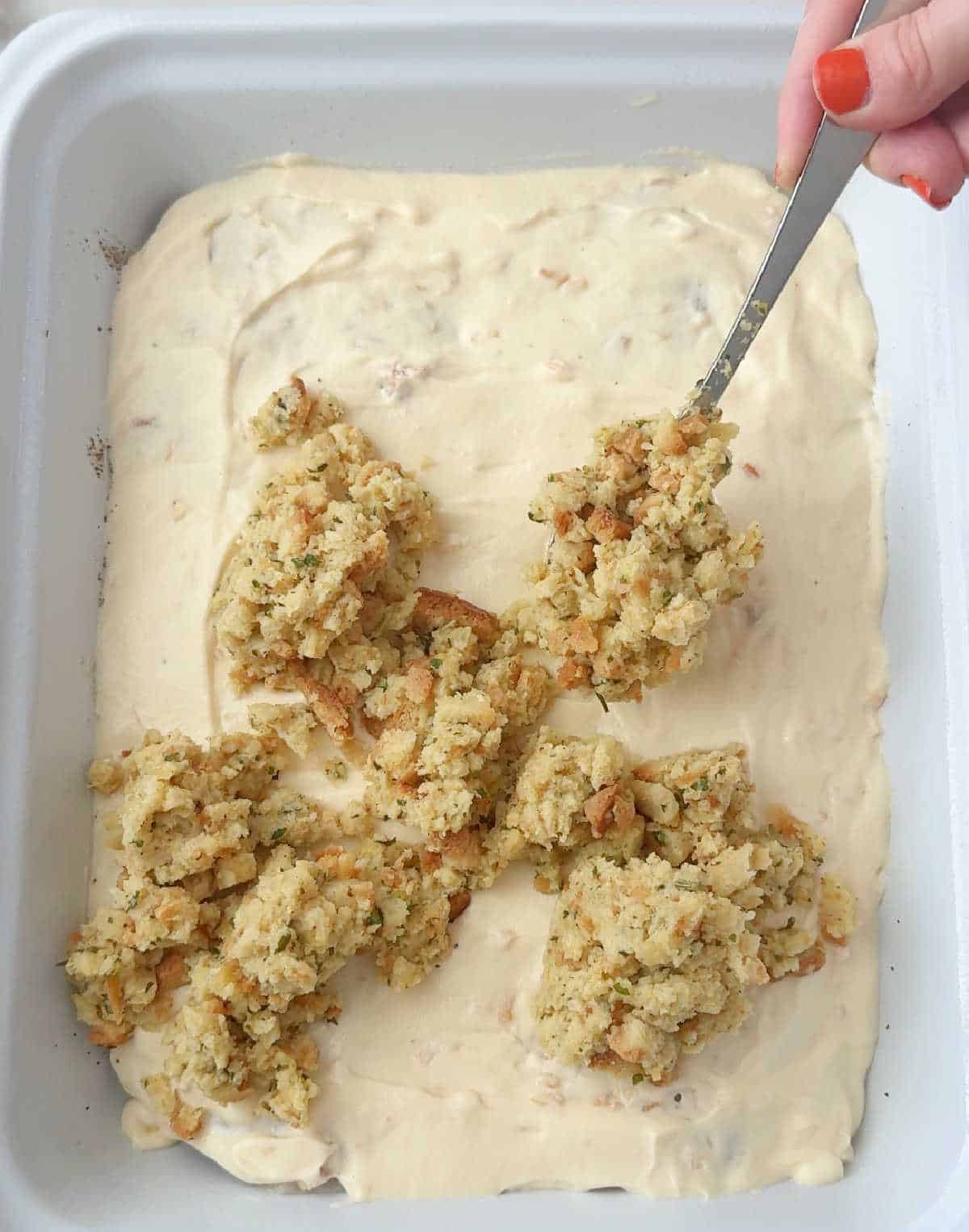 spooning stuffing on top of soup layer.