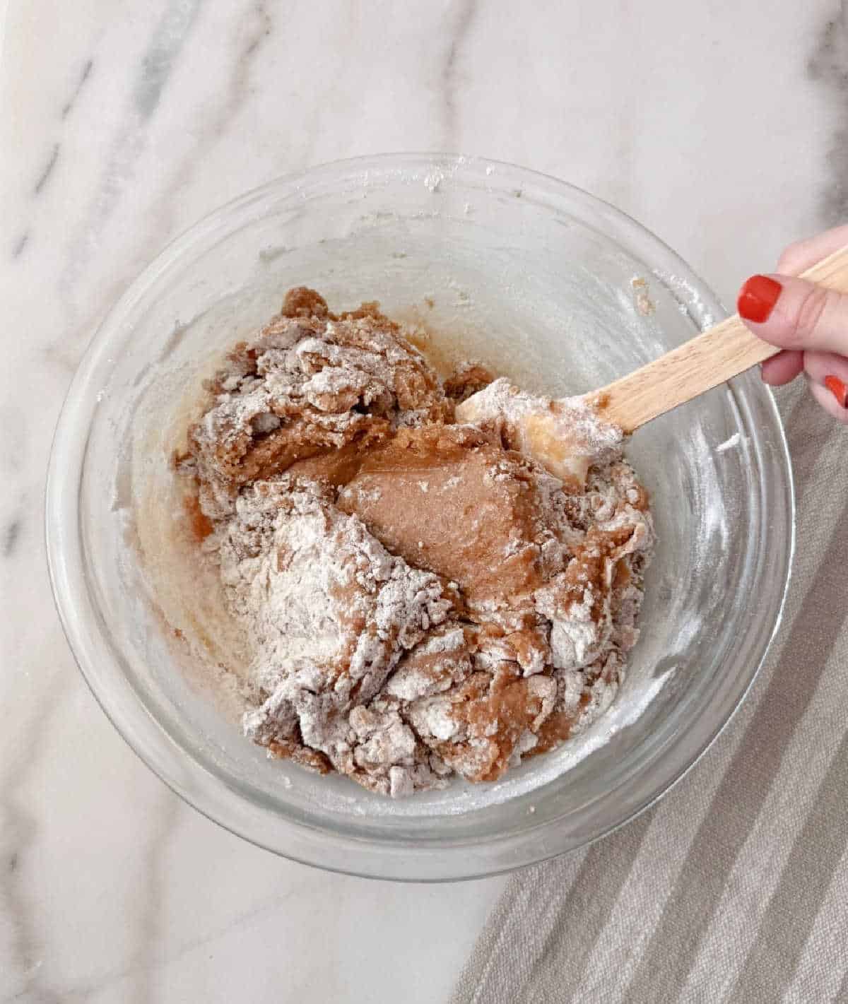 mixing wet with dry ingredients in bowl.