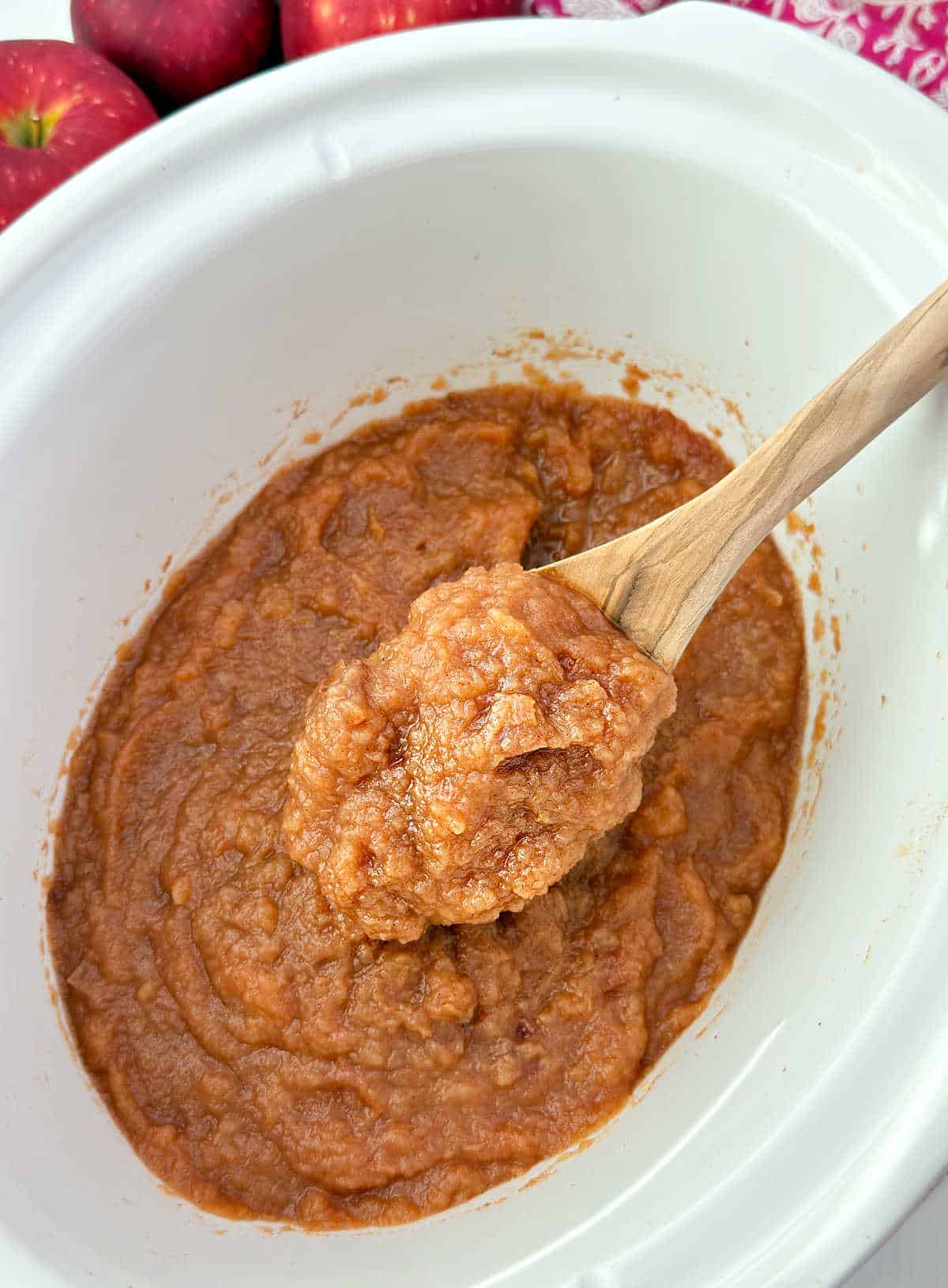 crockpot cinnamon applesauce on wooden spoon.