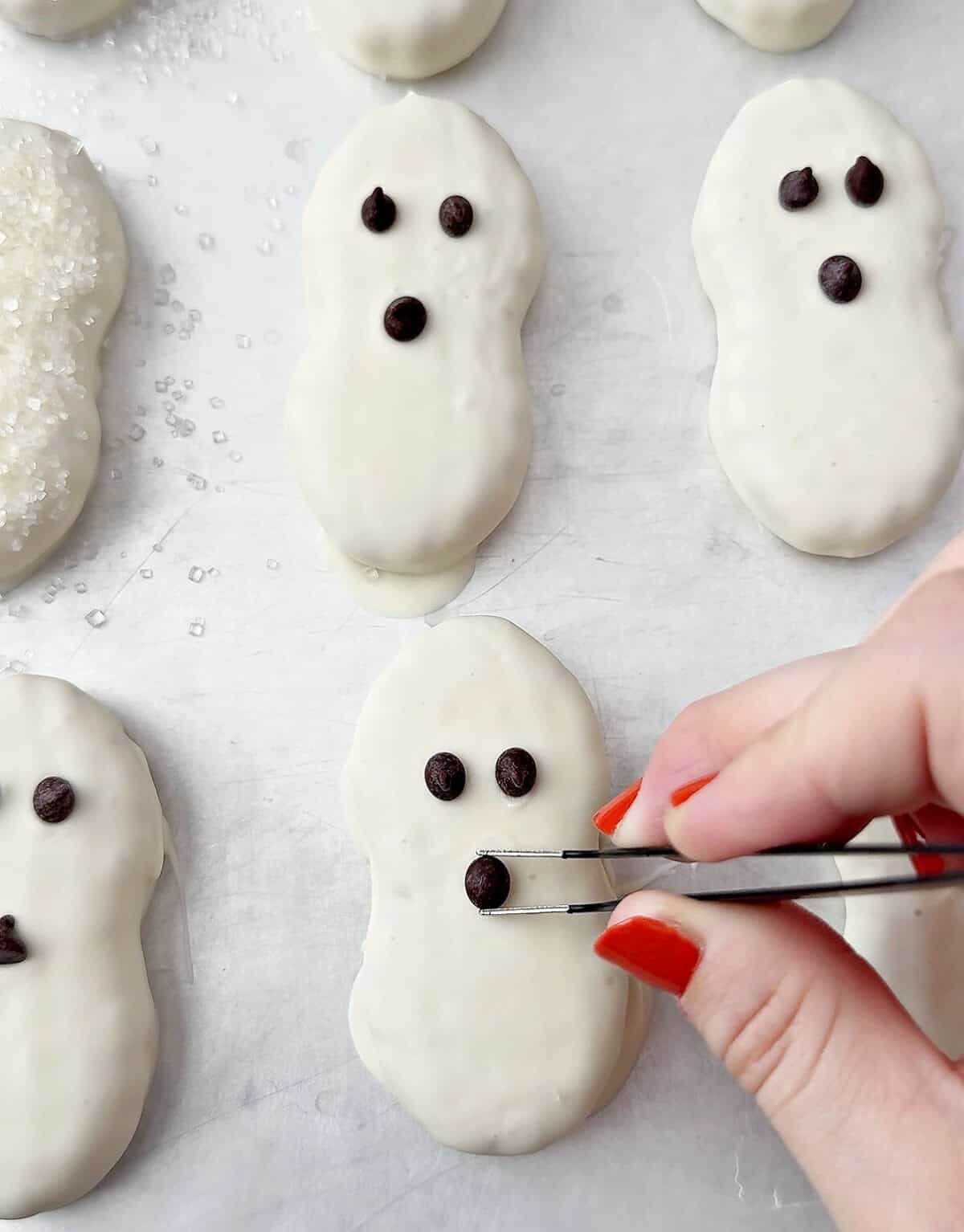 adding chocolate chips to ghost cookies.