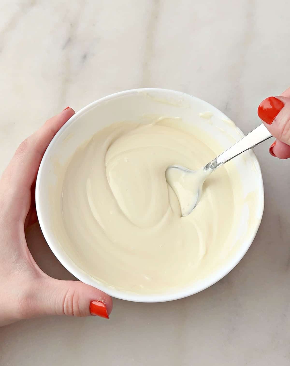 stirring melted white chocolate in bowl.