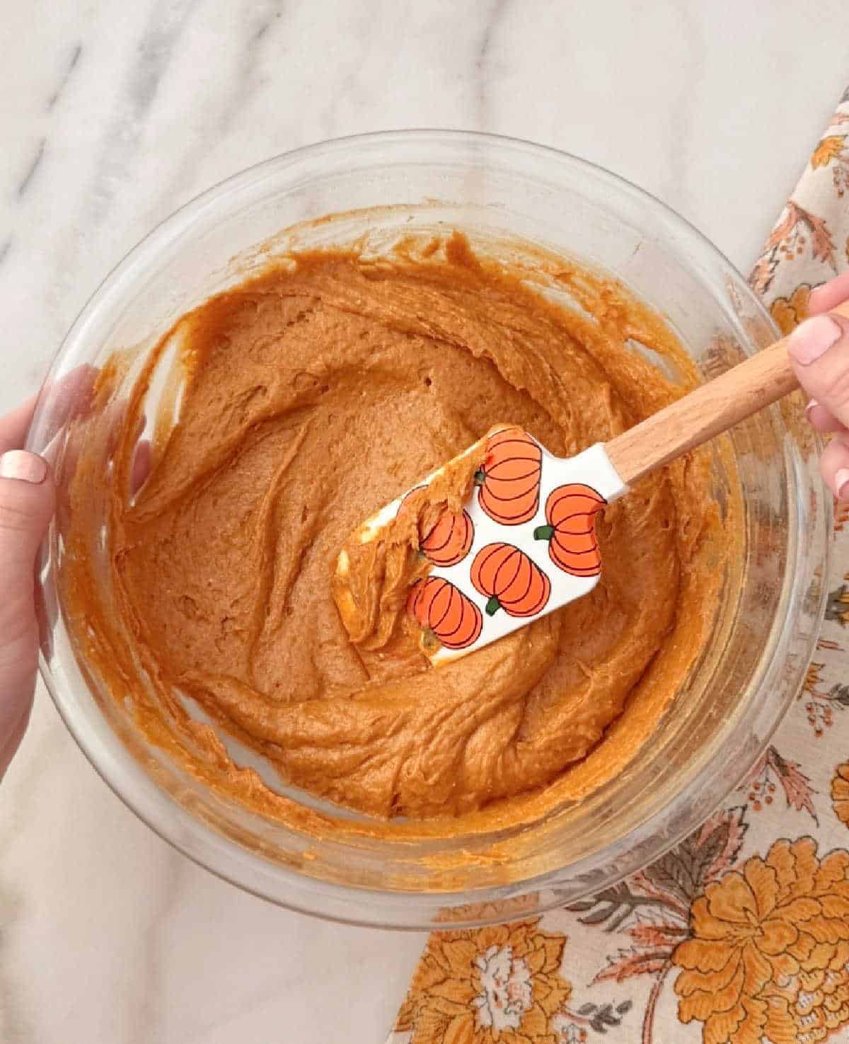 mixing batter with pumpkin spatula.