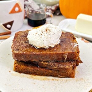 pumpkin bread French toast with whipped cream and maple syrup.