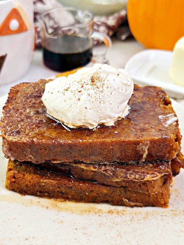 pumpkin bread French toast with whipped cream and maple syrup.