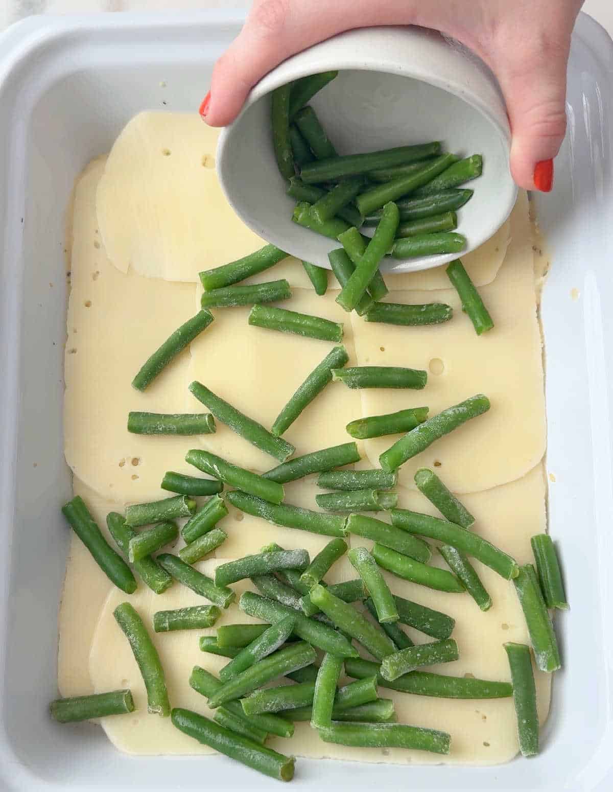 adding green beans over cheese layer.