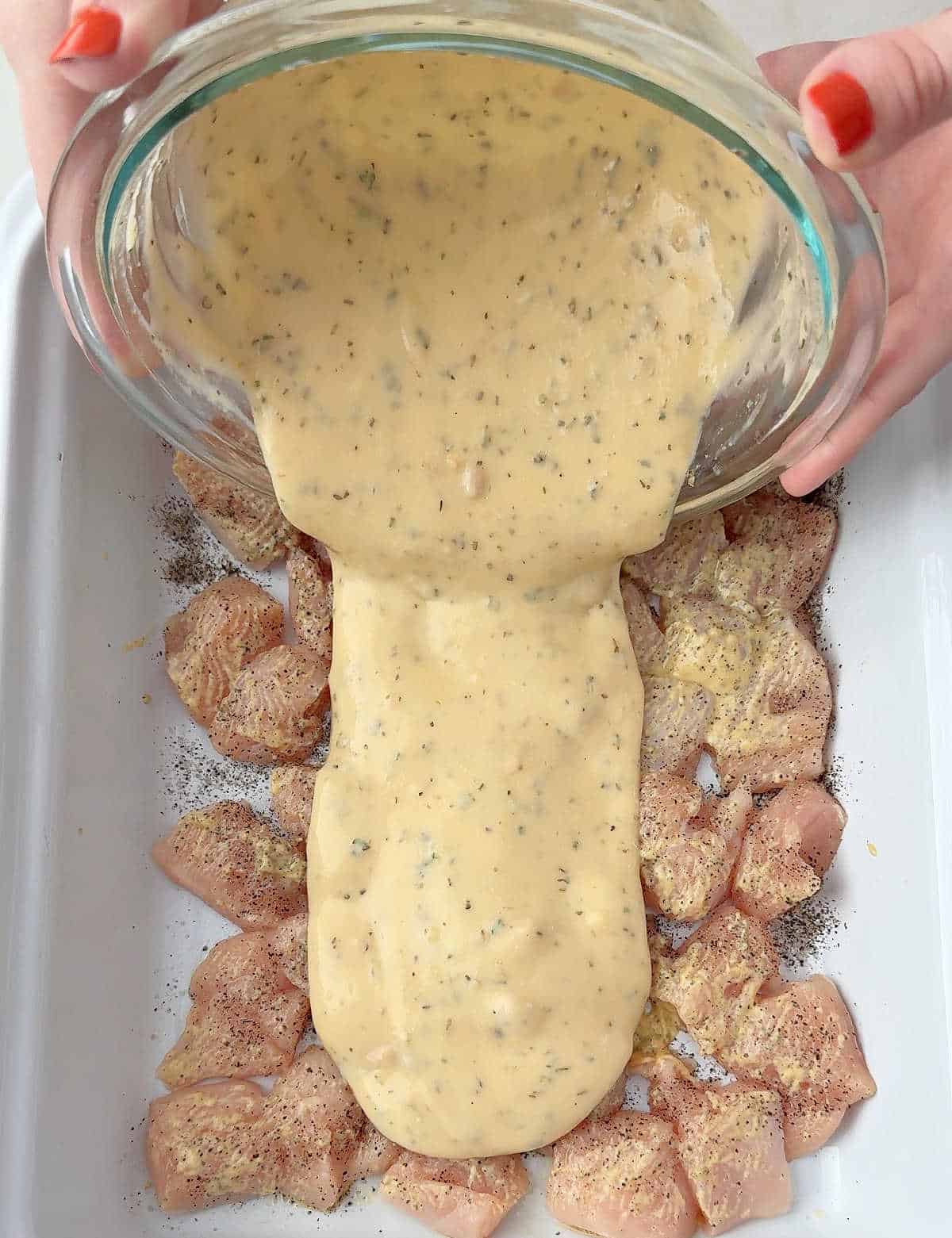 pouring sauce over chicken.