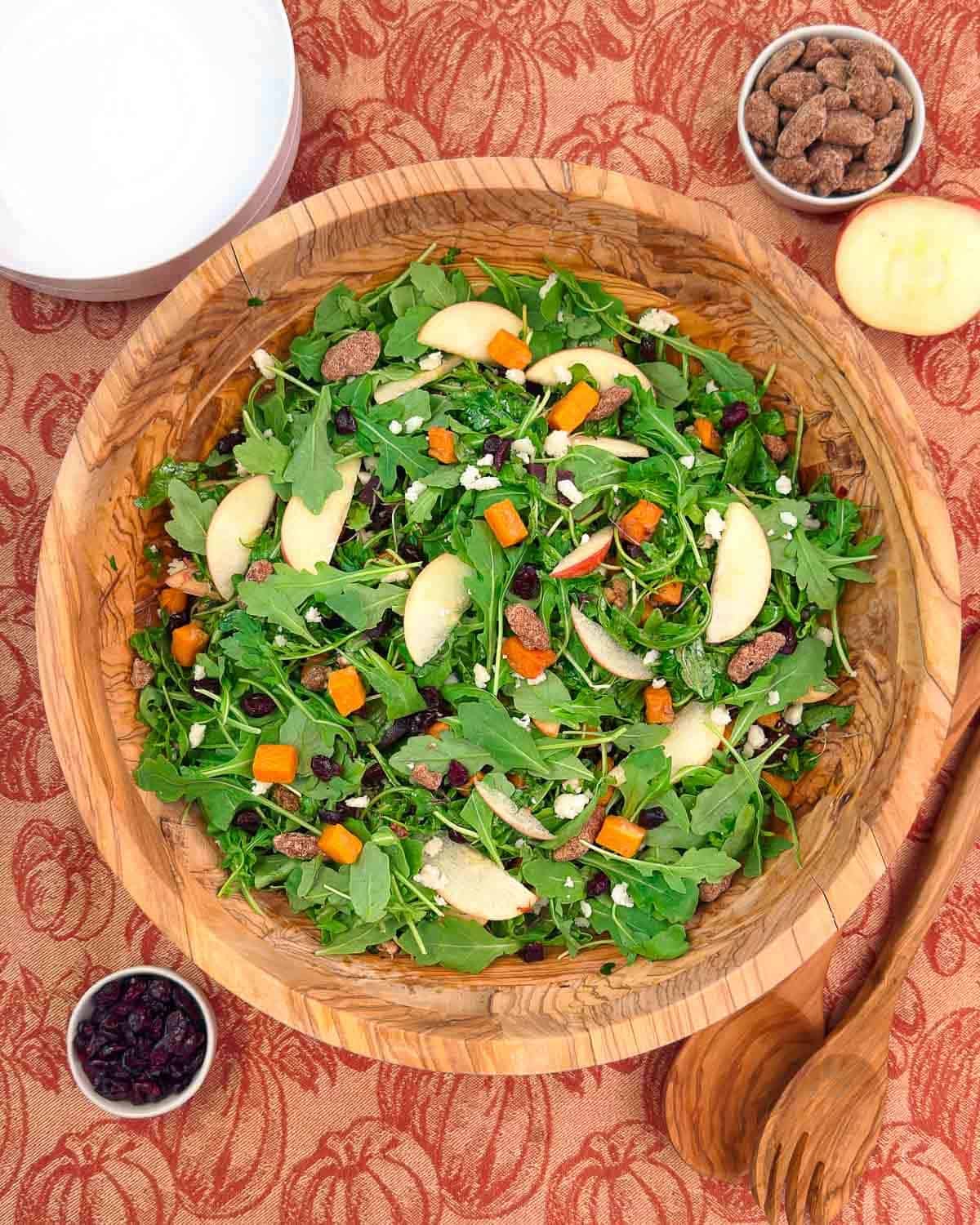 harvest salad with sweet potatoes and apples in a wooden bowl.