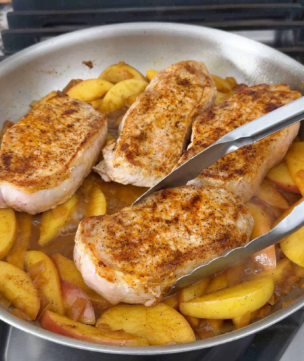 pork chops simmering in cider sauce.