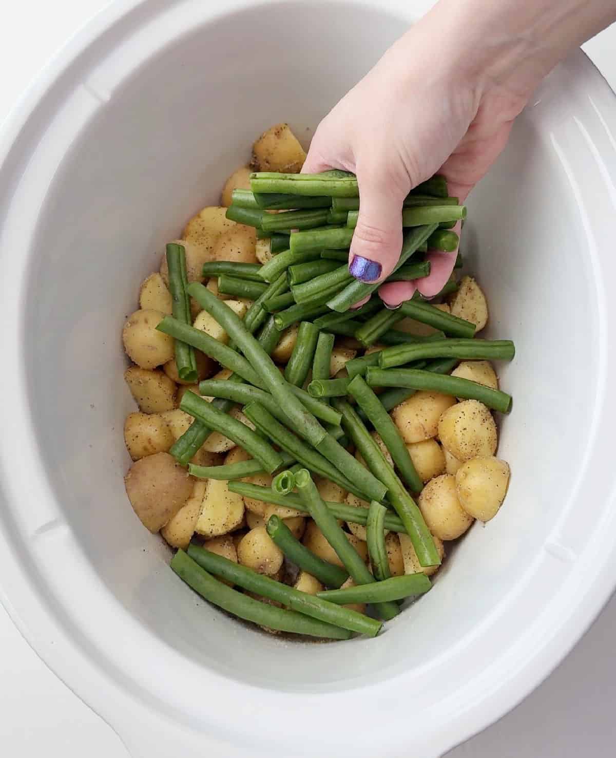 adding green beans over potatoes.