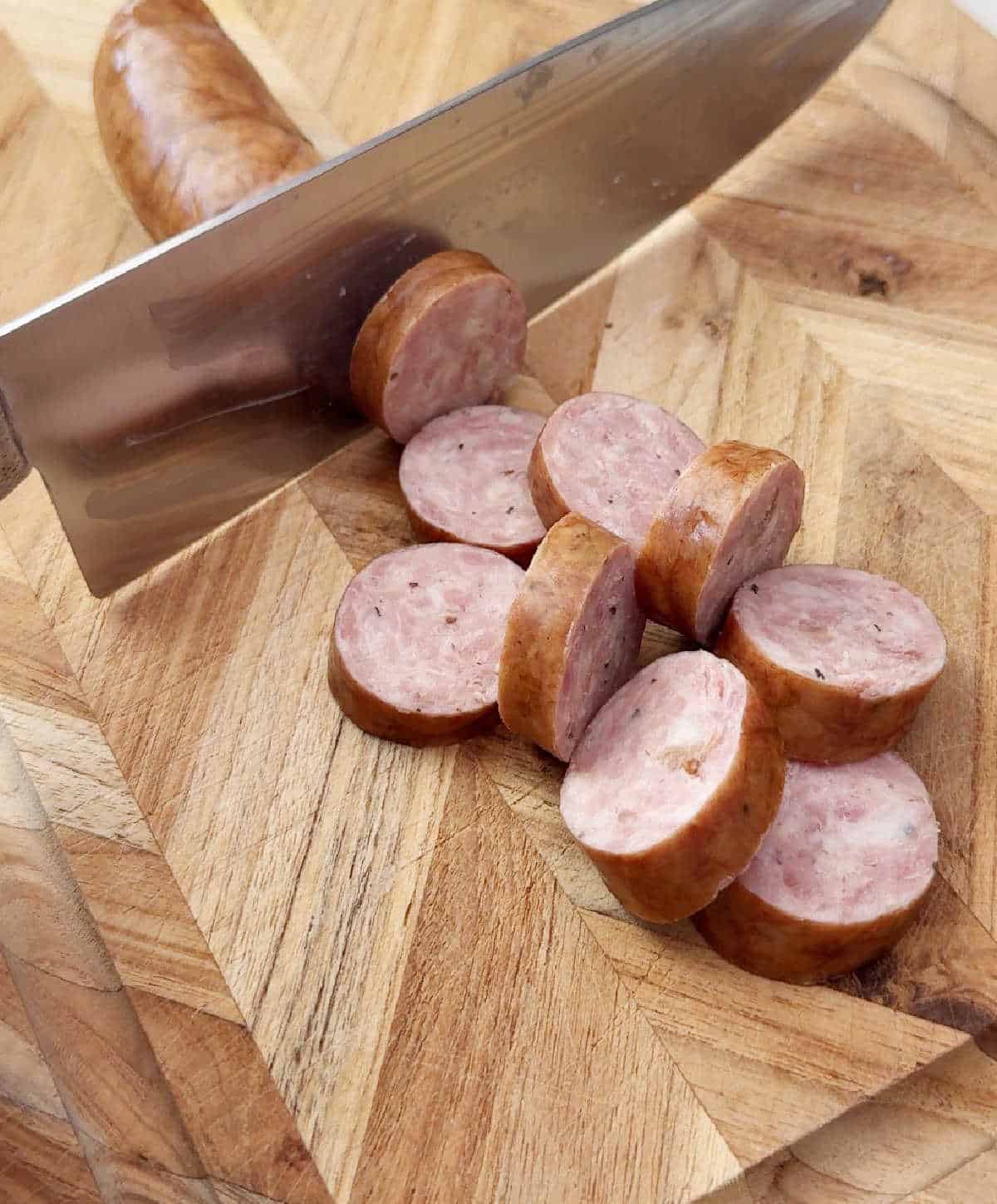 slicing smoked sausage into rounds.
