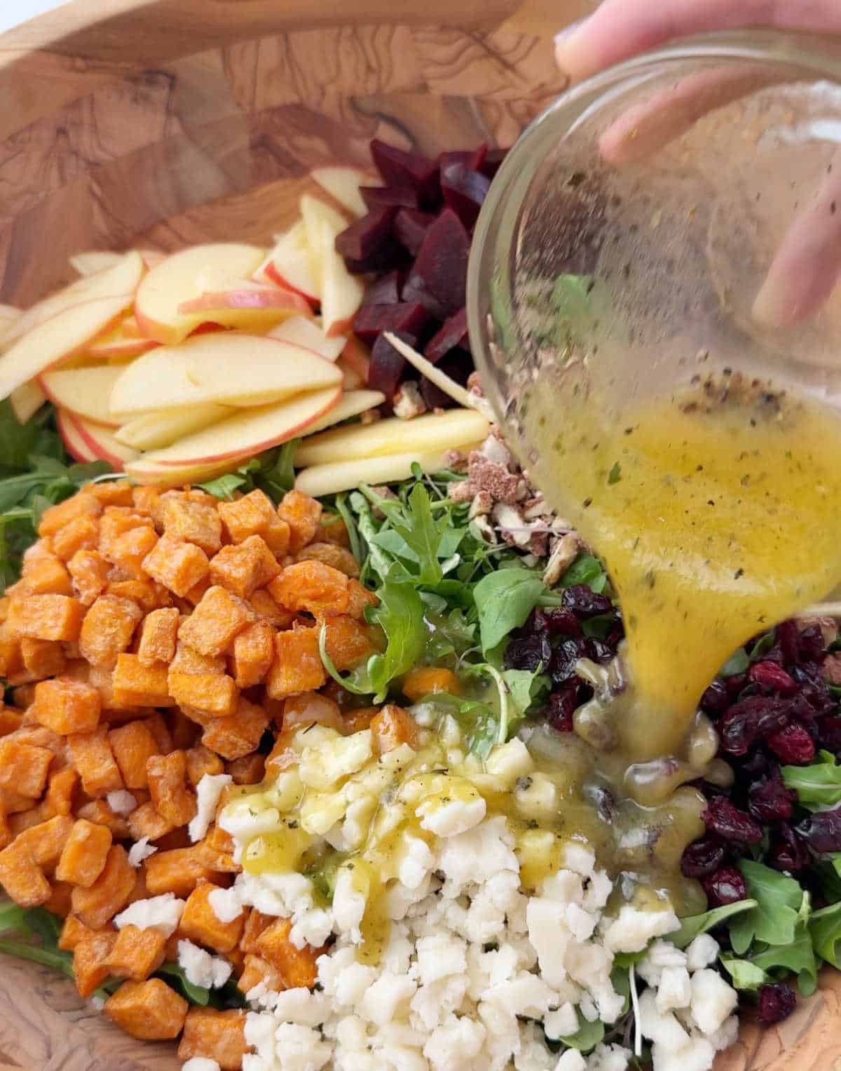 pouring dressing over salad.
