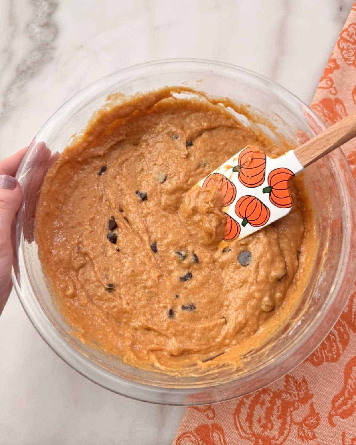 folding in chocolate chips with pumpkin spatula