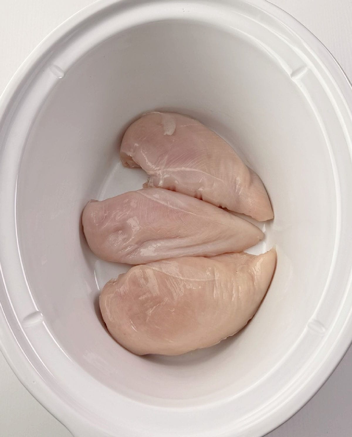 raw chicken breasts in crockpot.