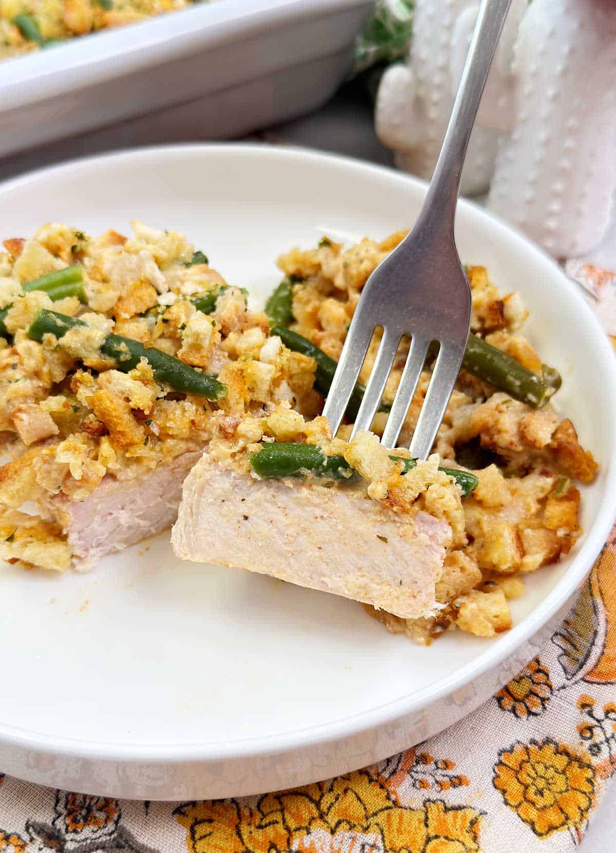 pork chop stuffing bake with green beans on fork.
